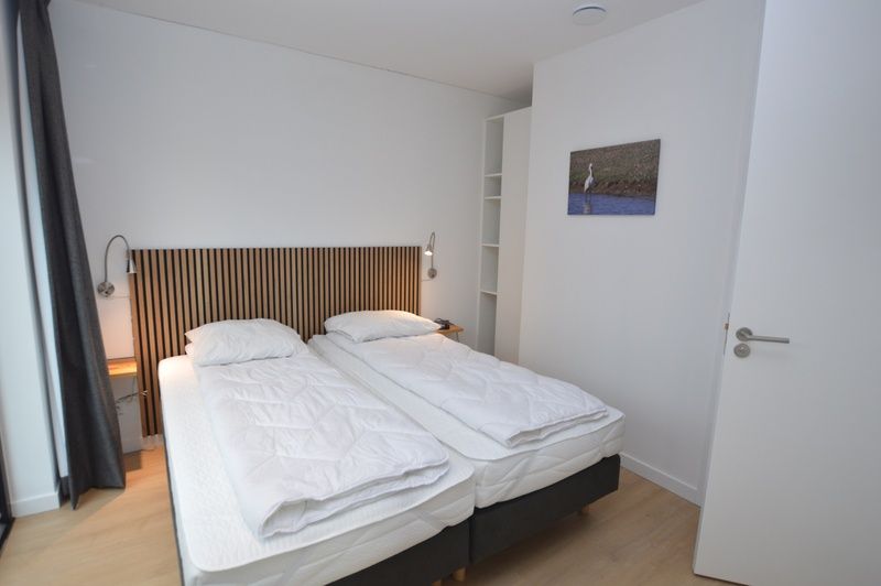 Comfortabele slaapkamer in Bungalow Uterste Coogh 132, De Dennen, Texel met twee eenpersoonsbedden.