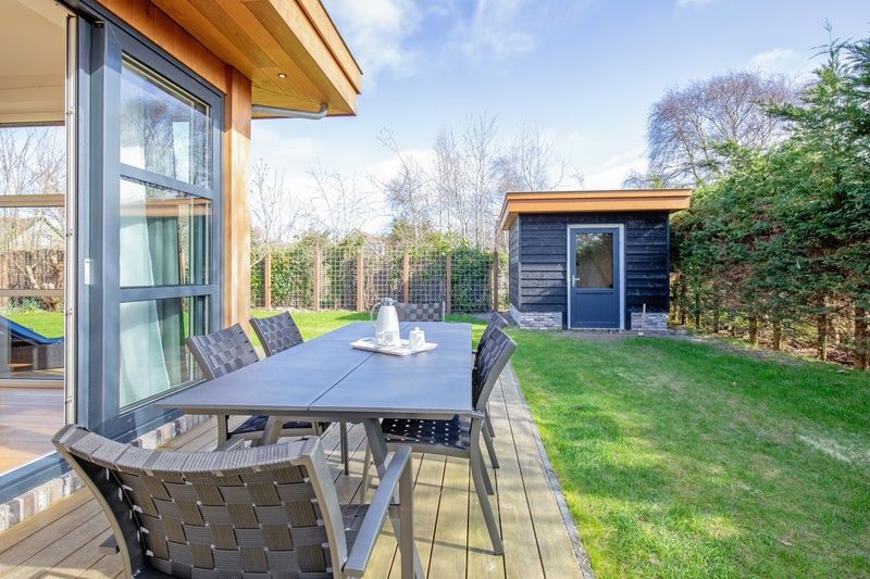 Cozy outdoor area of Holiday Home De Vlinder, Bungalowpark 't Hoogelandt, Texel, with dining table on the terrace.
