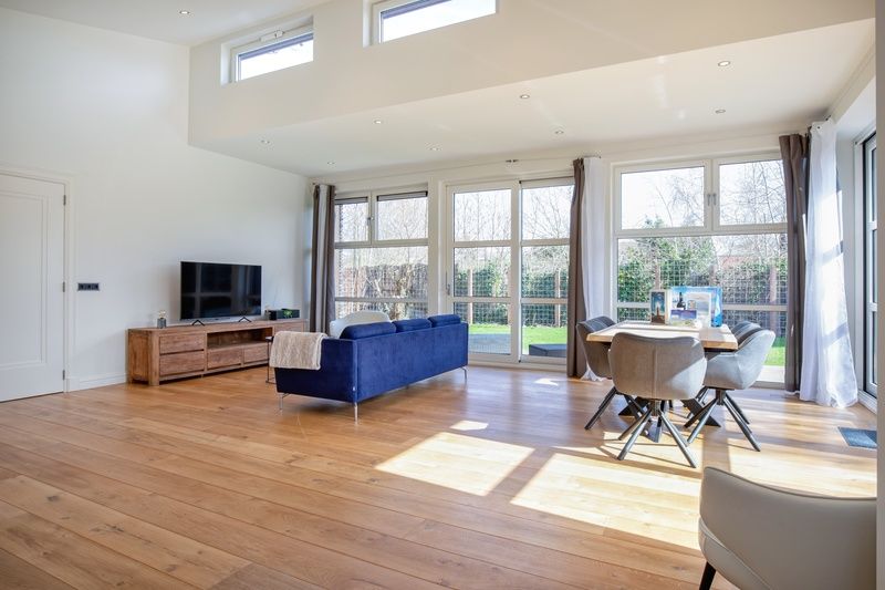 Open living room of Holiday Home De Vlinder, Texel, with lots of natural light and access to the garden.