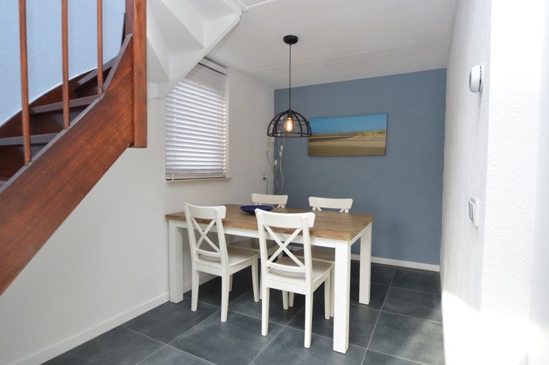 Eetgedeelte in vakantiehuis Gortersmient 240, Bungalowpark Gortersmient, De Dennen Texel met houten tafel en moderne lamp.