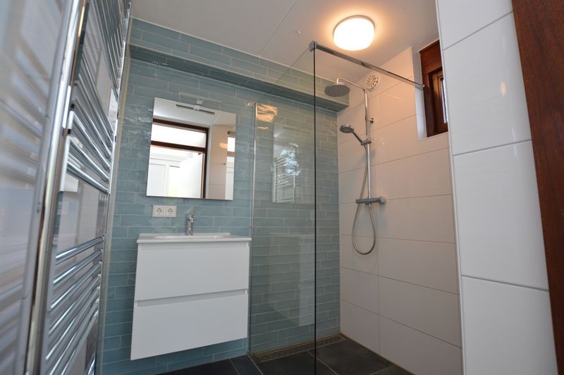 Frisse badkamer in vakantiehuis Gortersmient 240, Bungalowpark Gortersmient, De Dennen Texel met glazen douchewand en wastafel.