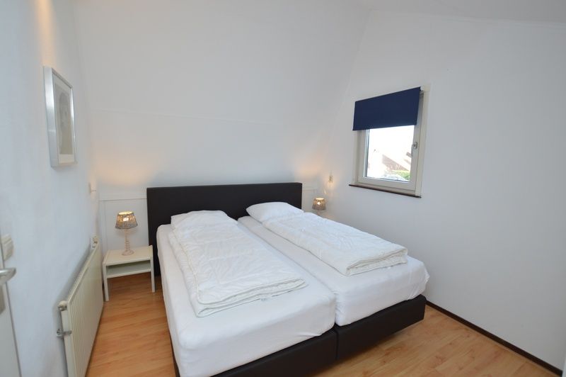 Comfortabele slaapkamer in vakantiehuis Gortersmient 240, Bungalowpark Gortersmient, De Dennen Texel met tweepersoonsbed.
