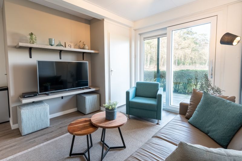 Comfortabele zithoek met tv in Appartement Bos en Duin 12, De Dennen, Texel, perfect voor ontspanning.