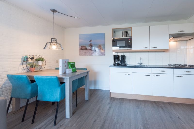 Moderne keuken en eetruimte in Appartement Bos en Duin 12, De Dennen, Texel, volledig uitgerust voor koken.