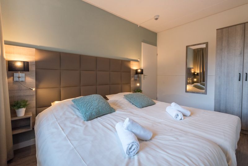 Ruime slaapkamer in Appartement Bos en Duin 12, De Dennen, Texel, met tweepersoonsbed en luxe inrichting.