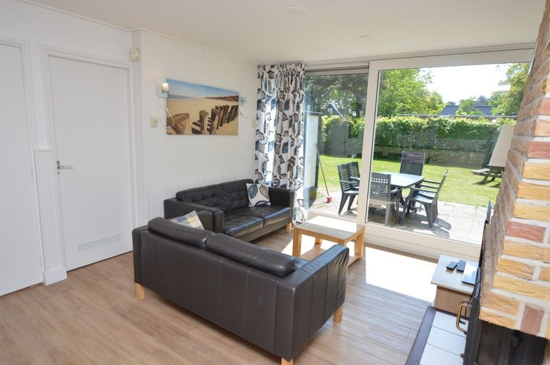 Comfortabele zithoek in Vakantiehuis de Parel 282, De Dennen, Texel met toegang tot het terras.