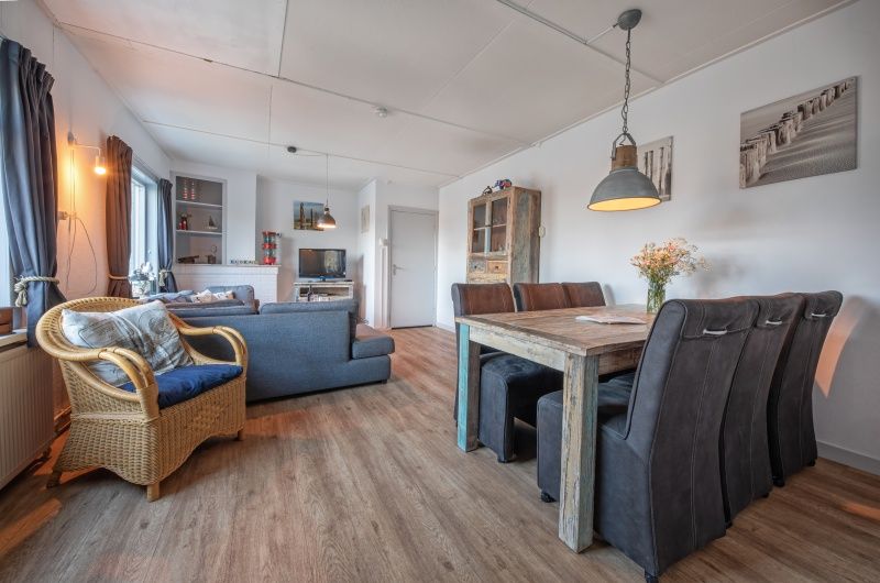 Gemuetliches Wohnzimmer des Ferienhauses Flora in De Dennen, Texel. Komfortable Sitz- und Essecke im gemuetlichen Ferienhaus auf den Watteninseln.