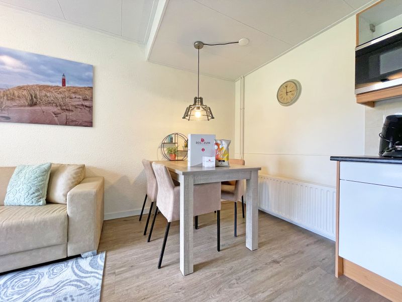 Essecke im Appartement Bos en Duin 14, Texel, mit gemuetlicher Atmosphaere und moderner Beleuchtung, ideal fuer Familienessen.