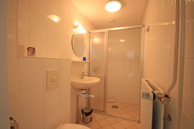 Frisches Badezimmer im Apartment Bos en Duin 14, De Dennen, Texel, mit moderner Dusche und weissen Fliesen.