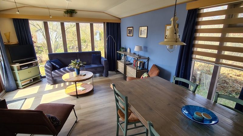 Innenraum des Ferienhauses im Vakantiepark De Bremakker, Texel, mit einem gemuetlichen Wohnzimmer und viel Licht.