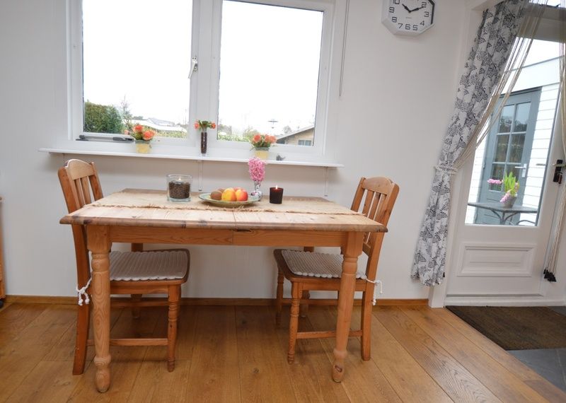 Gemuetlicher Essbereich im Bungalow Uterste Coogh 122, Texel, mit Holzmoebeln und natuerlichem Licht.