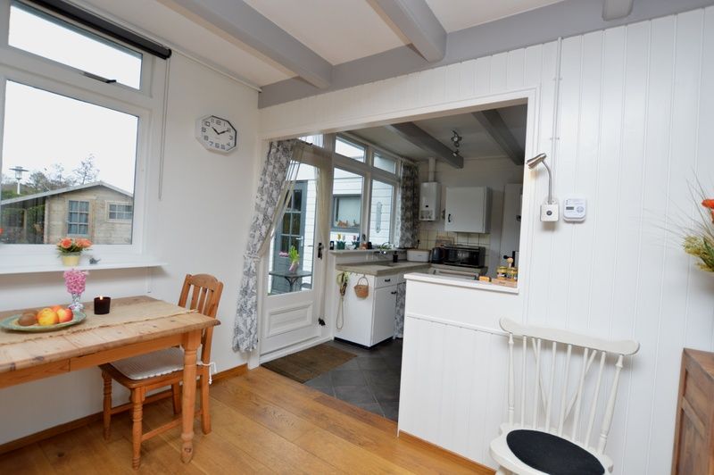 Kueche von Bungalow Uterste Coogh 122 in De Dennen, Texel mit modernen Geraeten und Gartenblick.