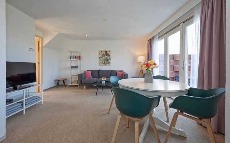 Ess- und Wohnbereich in Cottage 6, Texel. Helle, moderne Einrichtung mit Zugang zur Terrasse.