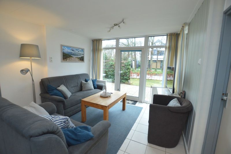 Gezellige woonkamer van Vakantiehuis de Parel 194 in De Dennen, Texel met uitzicht op de tuin.
