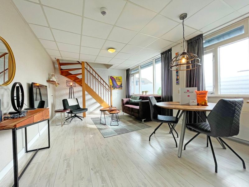 Stilvolle Essecke im Apartment Bos en Duin 25, De Dennen, Texel, mit Holztreppe und bequemen Sitzgelegenheiten.