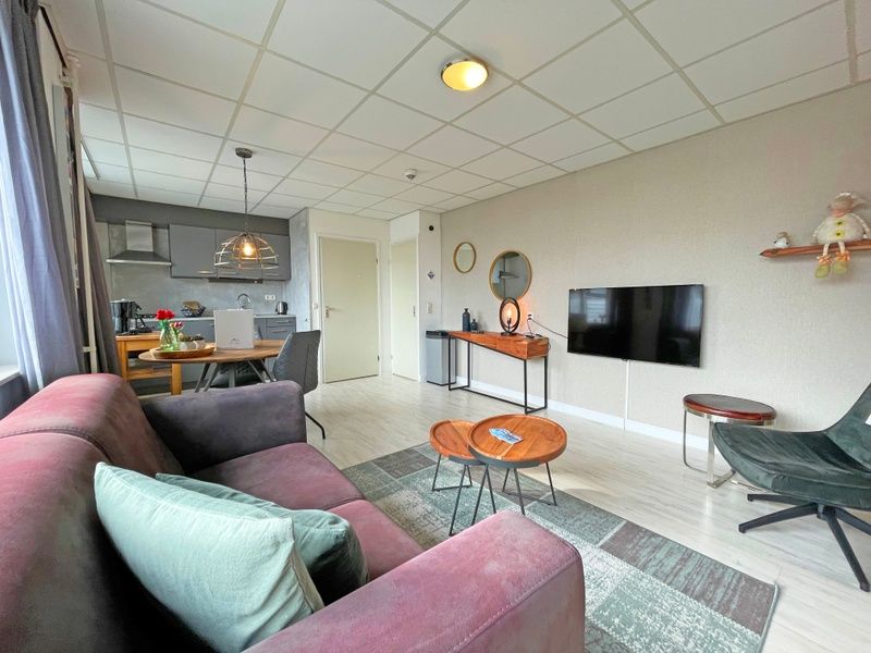 Offene Kueche und Wohnzimmer im Apartment Bos en Duin 25, De Dennen, Texel, mit moderner Ausstattung und gemuetlicher Atmosphaere.