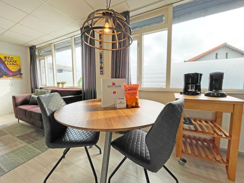 Essecke mit Aussicht im Appartement Bos en Duin 25, De Dennen, Texel, ideal fuer gemuetliche Mahlzeiten und Entspannung.