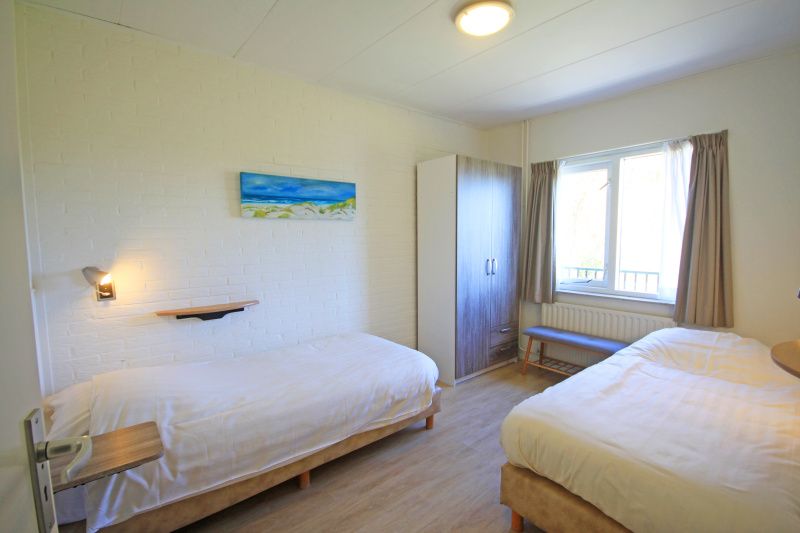 Zweites Schlafzimmer im Apartment Bos en Duin 31, De Dennen, Texel mit zwei Einzelbetten und viel Tageslicht.
