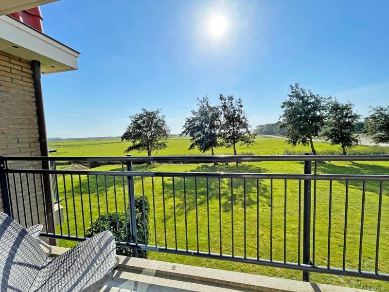 Blick vom Balkon des Appartements Bos en Duin 42, De Dennen, Texel ueber gruene Felder.