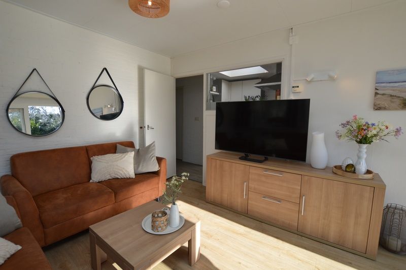Moderne woonkamer van Bungalow Uterste Coogh 96 in De Dennen, Texel met stijlvolle inrichting en ruime indeling.