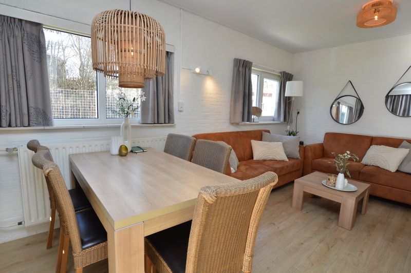 Eethoek in Bungalow Uterste Coogh 96, De Dennen, Texel, met uitzicht op de tuin, perfect voor familiediners.