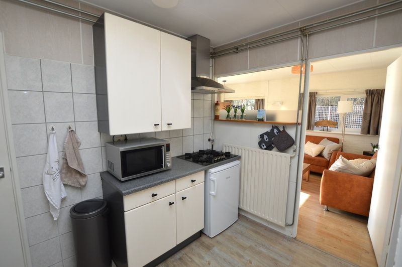 Keuken van Bungalow Uterste Coogh 96 in De Dennen, Texel, met moderne faciliteiten en toegang tot de woonkamer.