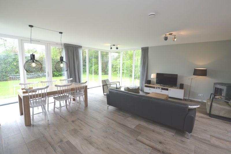 Helles Wohnzimmer im Ferienhaus Tempelierweg 16 - de Brunaire, De Dennen, Texel mit Blick auf den gruenen Garten, ideal fuer Familienurlaub.