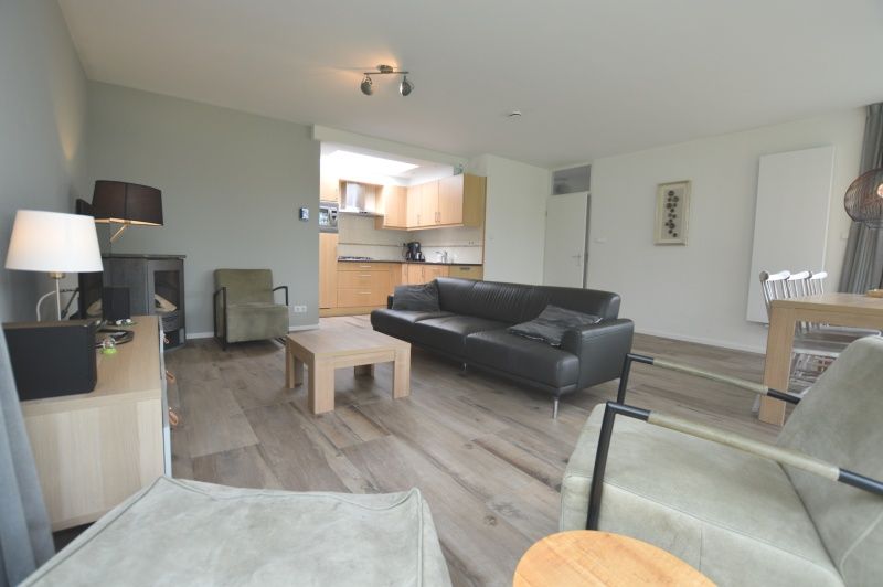 Gemuetlicher Wohnraum im Ferienhaus Tempelierweg 16 - de Brunaire, De Dennen, Texel, mit offener Kueche und grosszuegiger Sitzecke zum Entspannen.