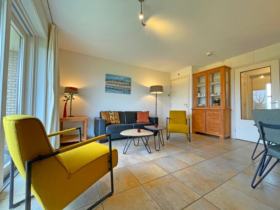 Gezellige woonkamer in Appartement Bos en Duin 41 in De Dennen, Texel met comfortabele zitplaatsen en veel natuurlijk licht.