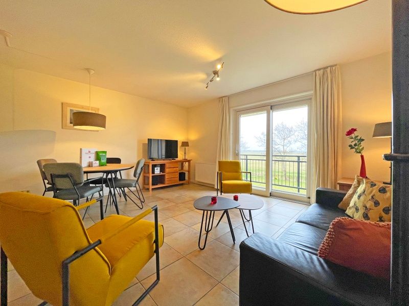 Uitzicht vanuit de woonkamer van Appartement Bos en Duin 41 in De Dennen, Texel met een serene landelijke omgeving.