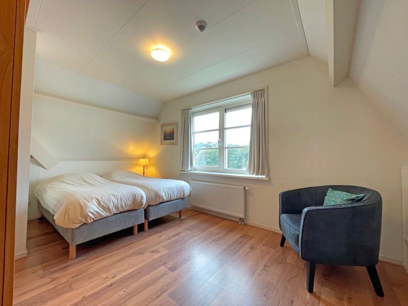 Tweede slaapkamer in Appartement Bos en Duin 41, De Dennen, Texel met twee eenpersoonsbedden en veel natuurlijk licht.