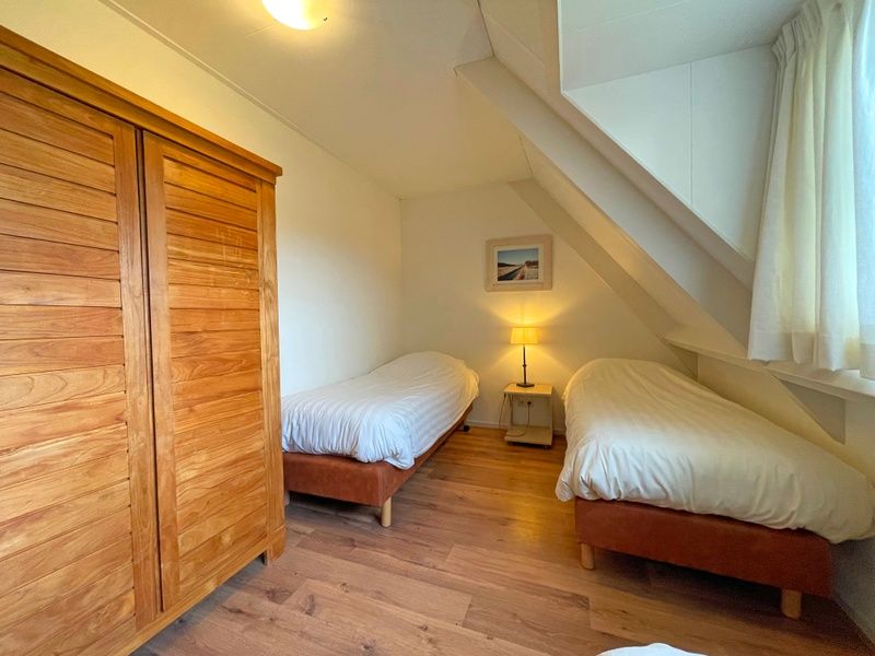 Balkon van Appartement Bos en Duin 41 in De Dennen, Texel met panoramisch uitzicht op het groene landschap.