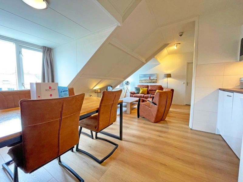 Dining room with wooden table in Apartment Bos en Duin 34, De Dennen, Texel.
