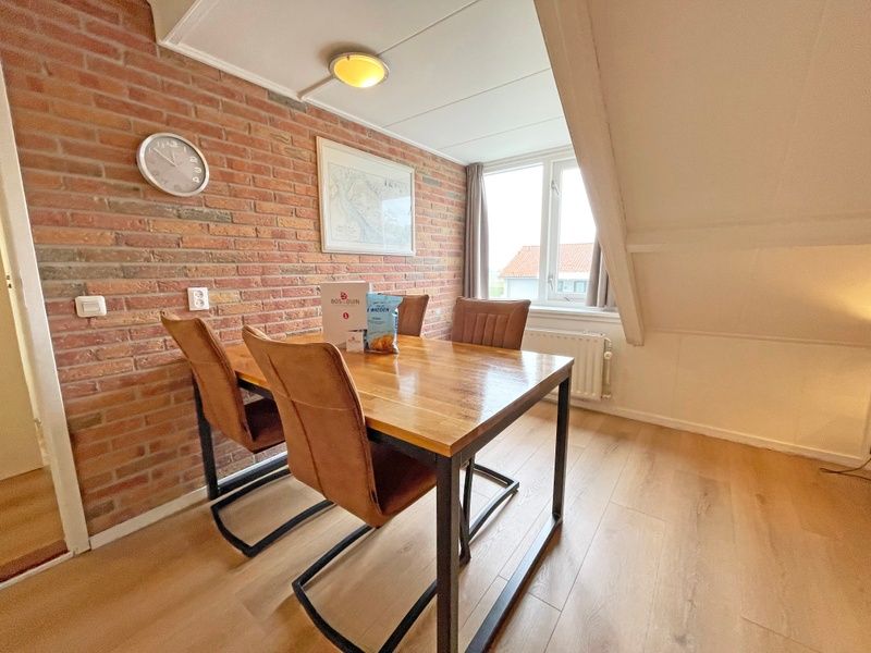 Cozy dining area in Apartment Bos en Duin 34, Texel with a view of the surroundings.