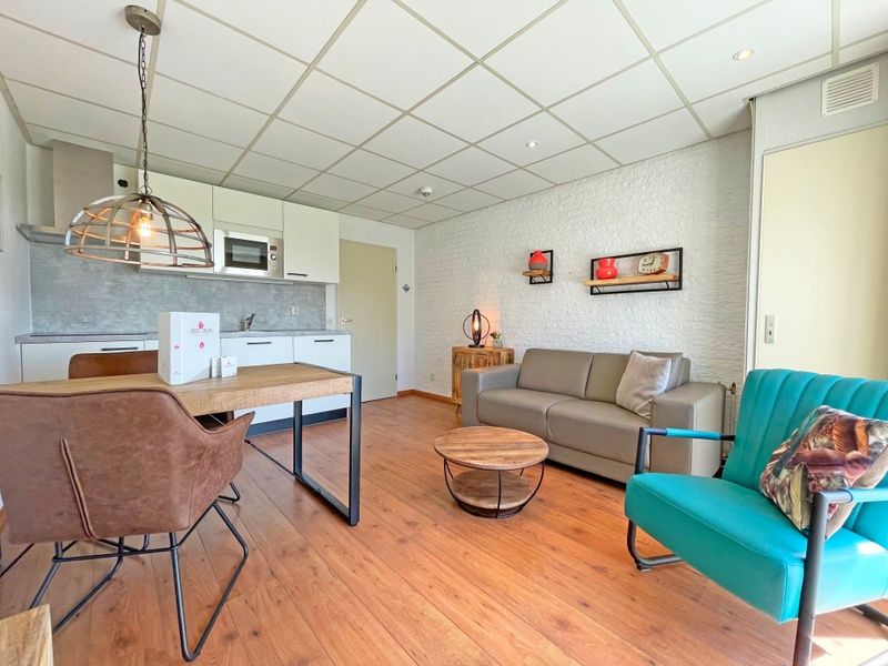 Moderne keuken en zithoek in Appartement Bos en Duin 18, De Dennen, Texel, ideaal voor een ontspannen vakantie op de Waddeneilanden.