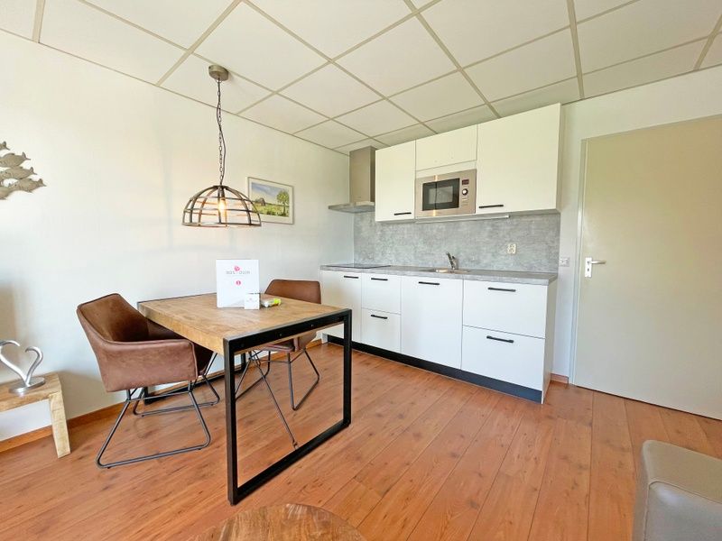 Eethoek en keuken in Appartement Bos en Duin 18, De Dennen, Texel met moderne voorzieningen en gezellige sfeer.