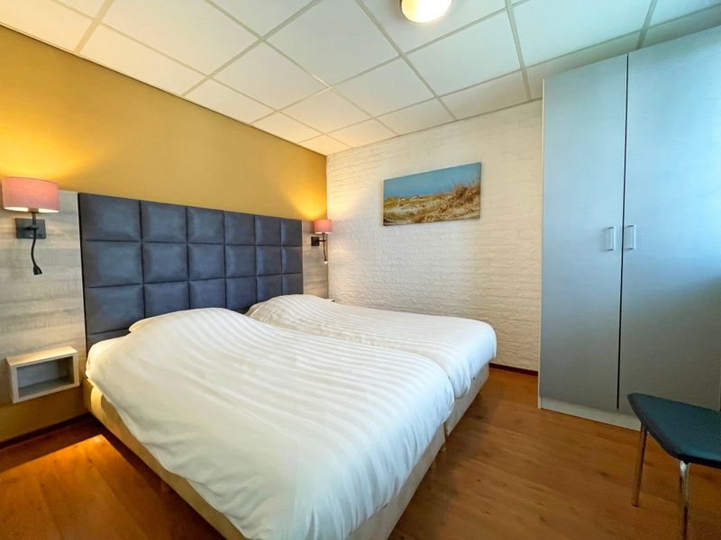 Comfortabele slaapkamer in Appartement Bos en Duin 18, De Dennen, Texel met tweepersoonsbed en rustgevende inrichting.