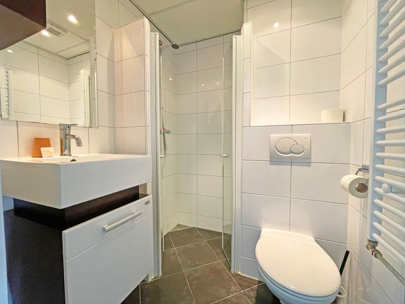 Moderne badkamer in Appartement Bos en Duin 18, De Dennen, Texel met douche en stijlvolle afwerking.