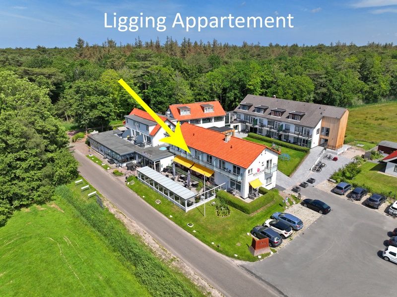 Luchtfoto van Appartement Bos en Duin 18, De Dennen, Texel, omgeven door natuur en dichtbij het bos.