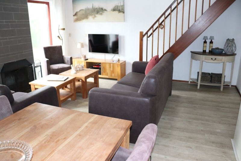 Modernes Wohnzimmer im Ferienhaus Gortersmient 252, De Dennen, Texel, mit TV und gemuetlicher Sitzgelegenheit.