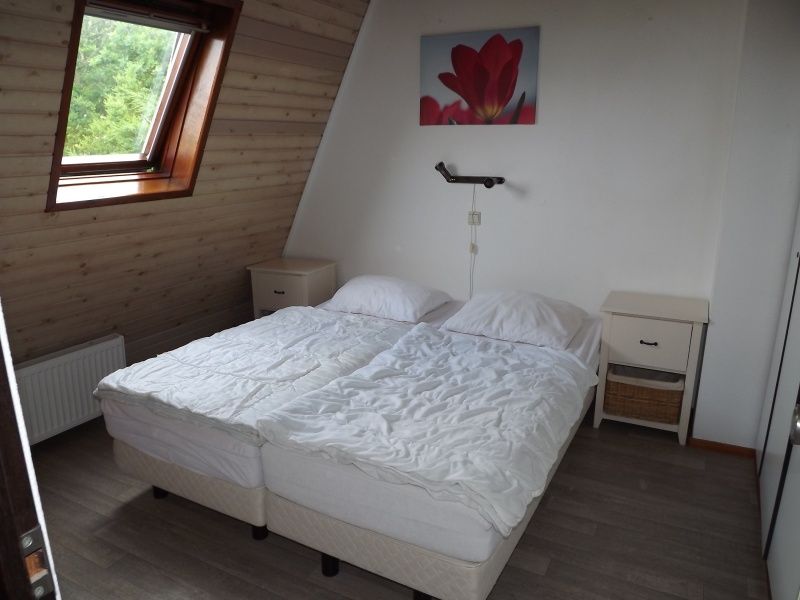 Schlafzimmer mit Doppelbett im Ferienhaus Gortersmient 252, De Dennen, Texel, mit natuerlichem Licht und ruhiger Atmosphaere.