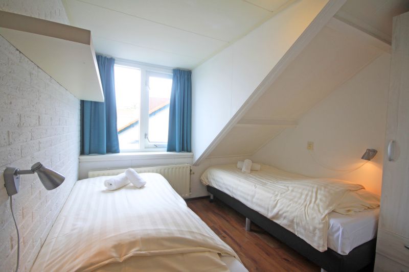 Zweites Schlafzimmer im Appartement Bos en Duin 33, De Dennen, Texel mit zwei Betten und ruhigem Ambiente.
