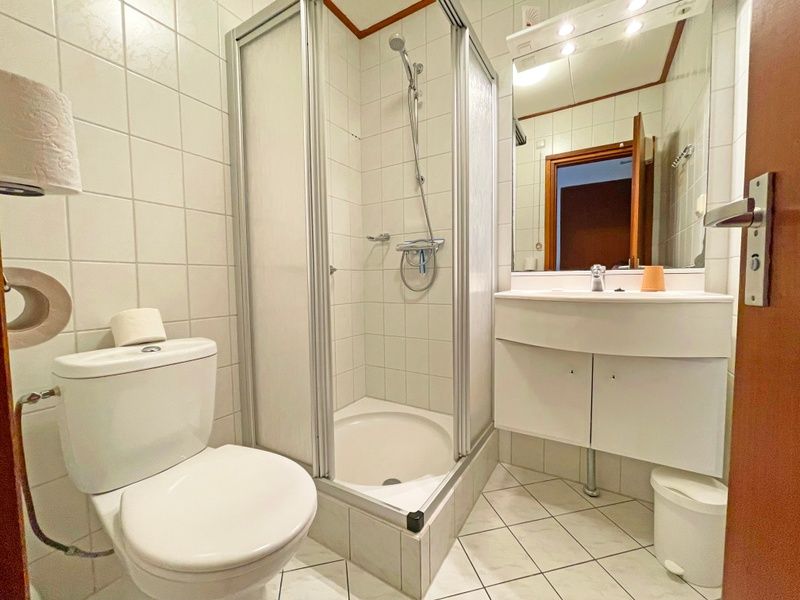 Frisches Badezimmer im Appartement Bos en Duin 33, De Dennen, Texel mit Dusche, Toilette und Waschbecken.