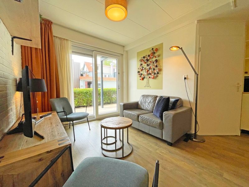 Zithoek van Appartement Bos en Duin 10 in De Dennen, Texel met uitzicht op het terras.