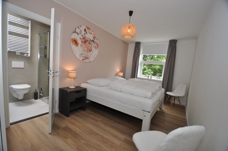 Sfeervolle slaapkamer in Bungalow Verste Coogh 62, Texel met eigen badkamer, ideaal voor een ontspannen verblijf in De Dennen.