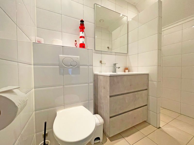 Stijlvolle badkamer in Appartement Bos en Duin 36, De Dennen, Texel met moderne wastafel en toilet.