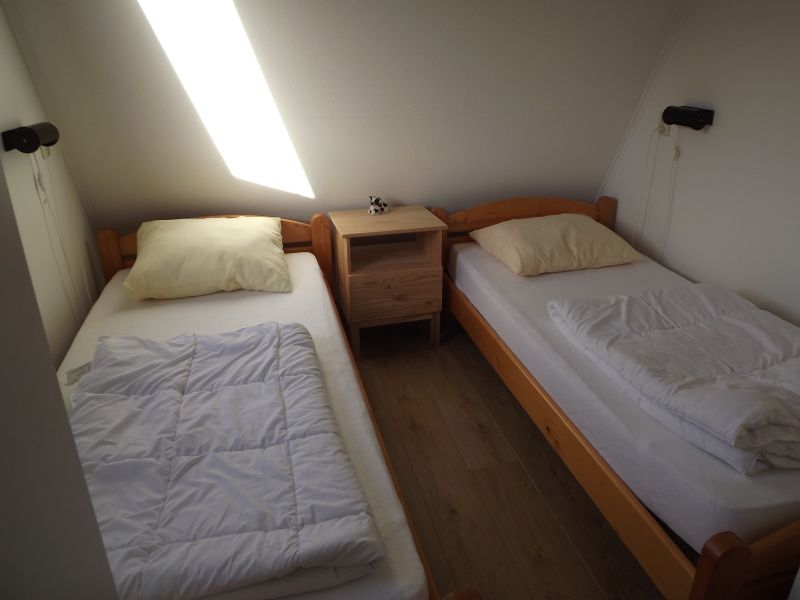 Tweepersoonsbedden in knusse slaapkamer van Vakantiehuis Gortersmient 210, De Dennen, Texel.