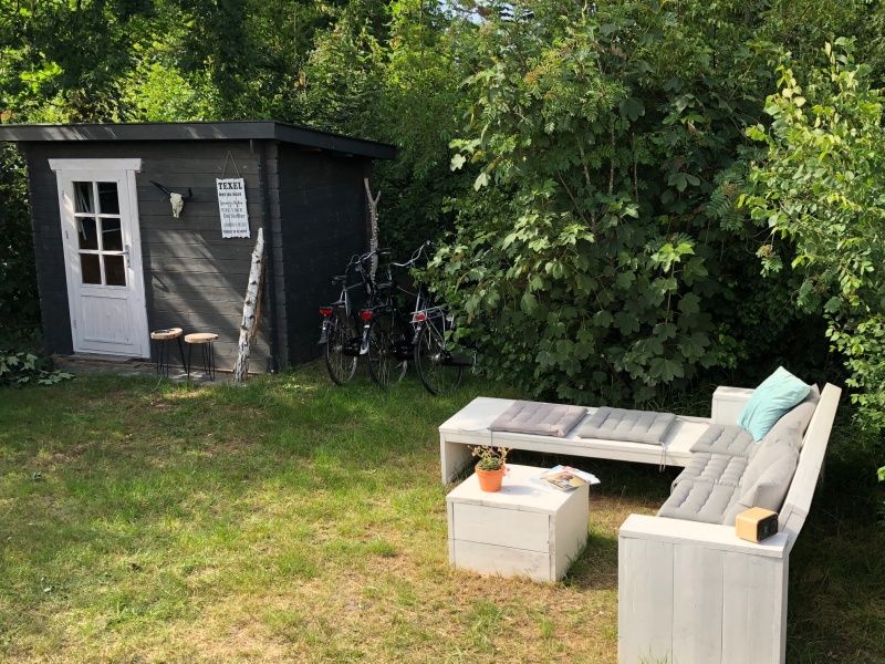Relax in the green garden of Vakantiepark de Bremakker - Chalet on Texel, Weideveld 80, with comfortable sitting area in De Dennen, Texel.