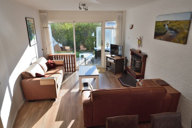 Lichte leefruimte in Vakantiehuis de Parel 200, De Dennen Texel met uitzicht op tuin.