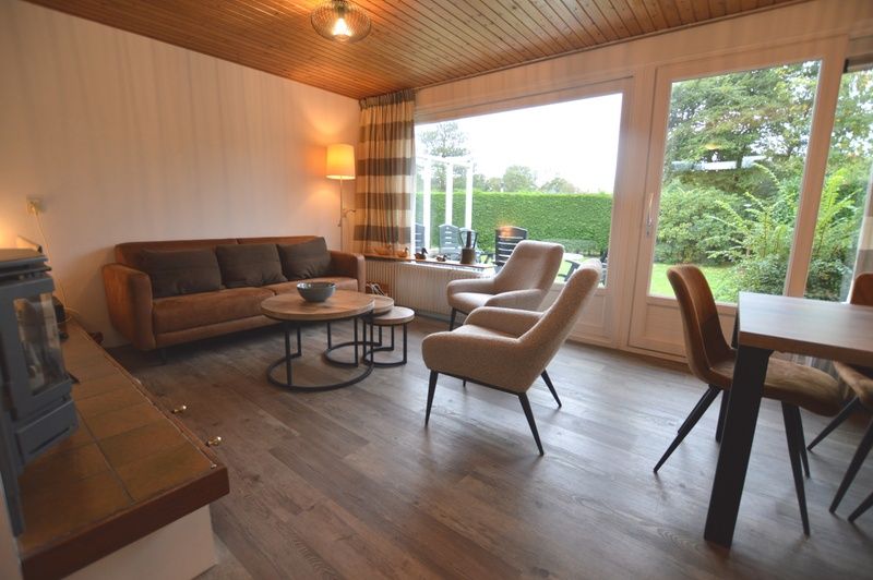 Gemuetliches Wohnzimmer des Ferienhauses de Parel 234 in De Dennen, Texel mit Blick auf den Garten.
